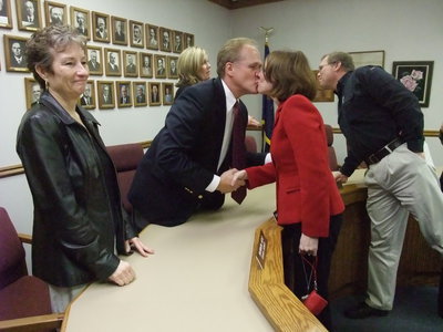 Image: Stealing a kiss — Simmons receives a congratulatory kiss from his wife, Ruth.