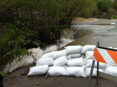 Image: City crews successfully sandbagged the road to force the creek back into the channel