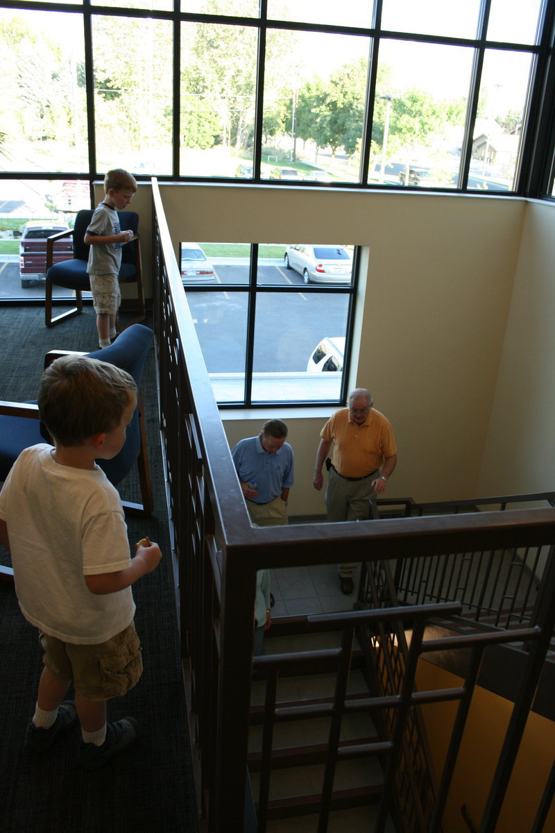 Image: Cookies — Two young boys eat cookies while watching people tour the new city offices