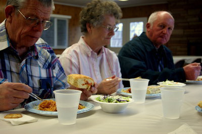 Image: Old friends and neighbors spend the evening catching up over a plate of spaghetti.