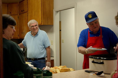 Image: Lion’s Club members and volunteers stop for a chat after manning the kitchen.