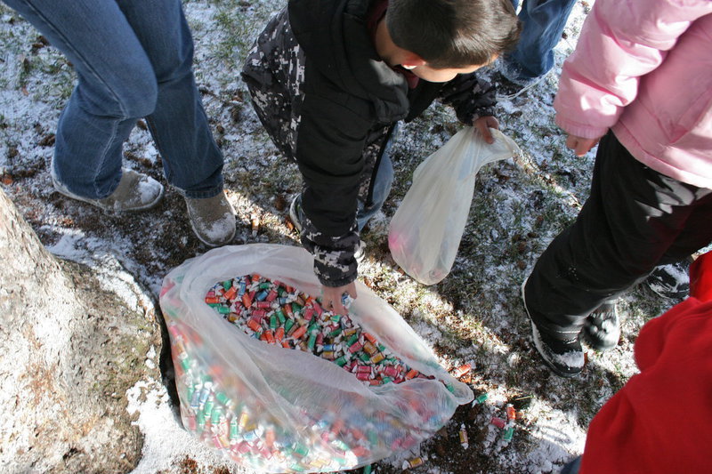 Image: Bags o’ candy — Grabbing handfuls of candy from the bags and boxes of candy set under trees and other dry places so the snow wouldn’t ruin them.
