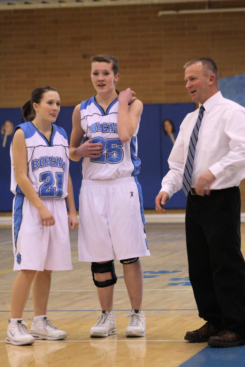 Image: Coach instructs — Sydnee Johnson and Jessica Duffin listening to Coach Paul Hansen during the game.