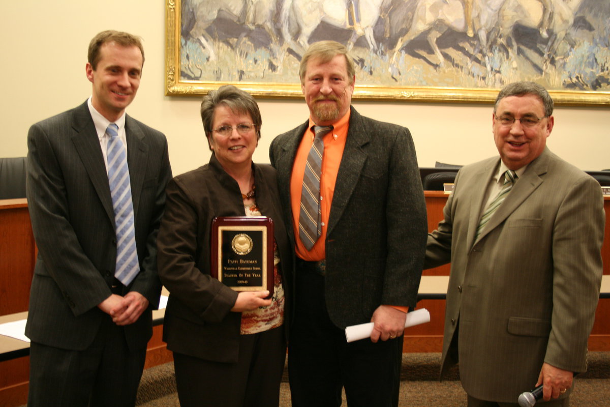 Image: Patti Bateman — Jonathan Jenkins, board president; Patti Bateman, 1st grade teacher; Cody Dobson, principal; and Steve Norton, superintendent. Patti holding her award as Teacher of the Year for Wellsville elementary school.