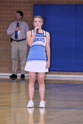 Image: Julia Smith — Julia Smith sings the national anthem before the game.