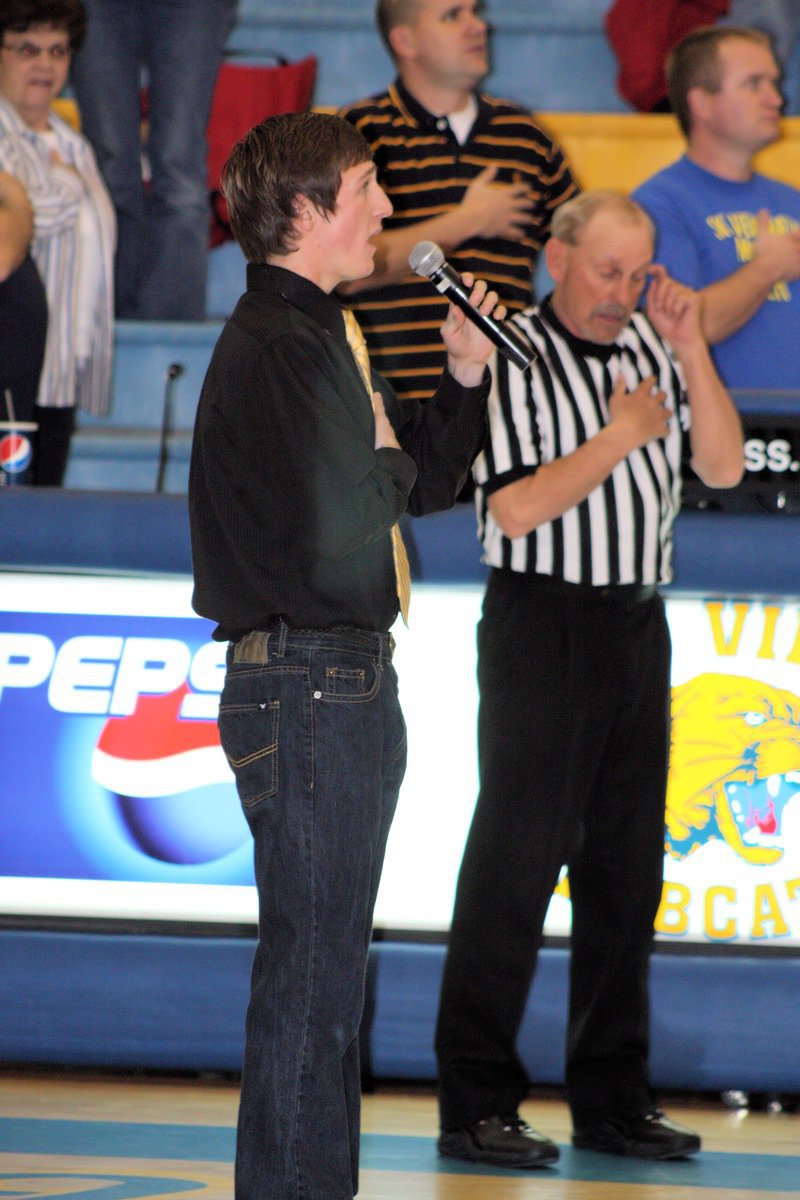 Image: Taylor Jensen — Taylor Jensen, senior, sings the national anthem to start the game.