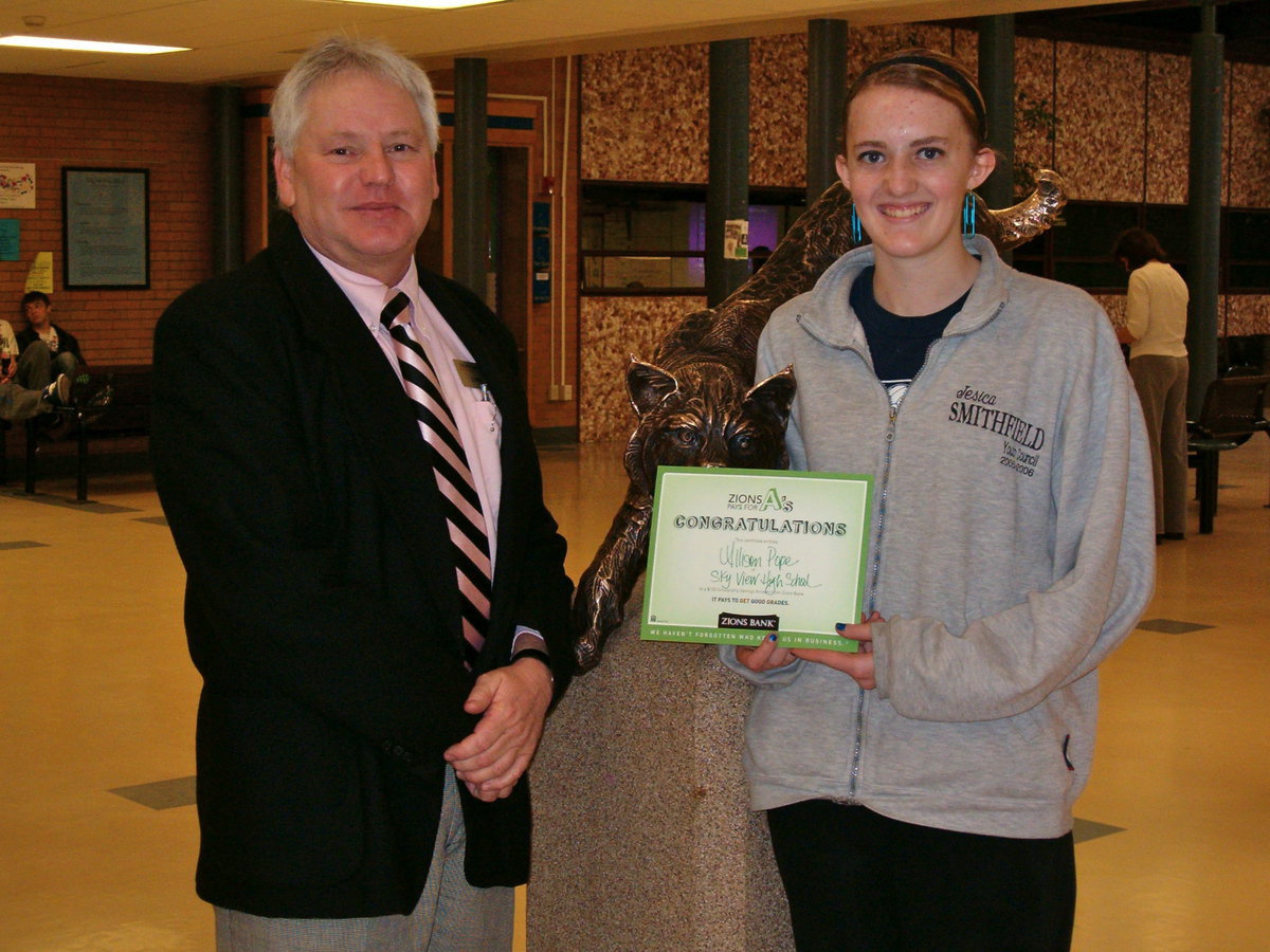 Image: Lynn Godderidge and Allison Pope — Lynn Godderidge of the Smithfield Zions Bank presented Allison Pope a $100 scholarship savings account from Zions Bank’s Pays for A’s program.