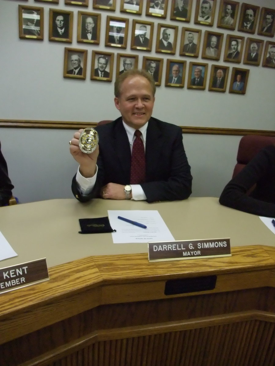 Image: Police badge — Simmons showing the official city police badge received as a gift from Chief Johnny McCoy.