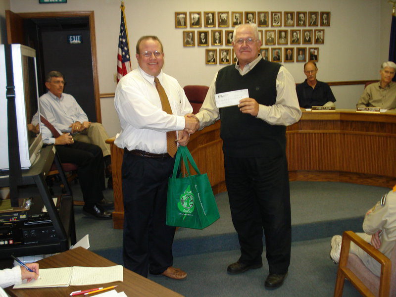 Image: Lee’s Marketplace donation — Pete Krusi, Lee’s Marketplace store director, handing Mayor Chad Downs a $500 check raised as part of the store’s reusable bags program.