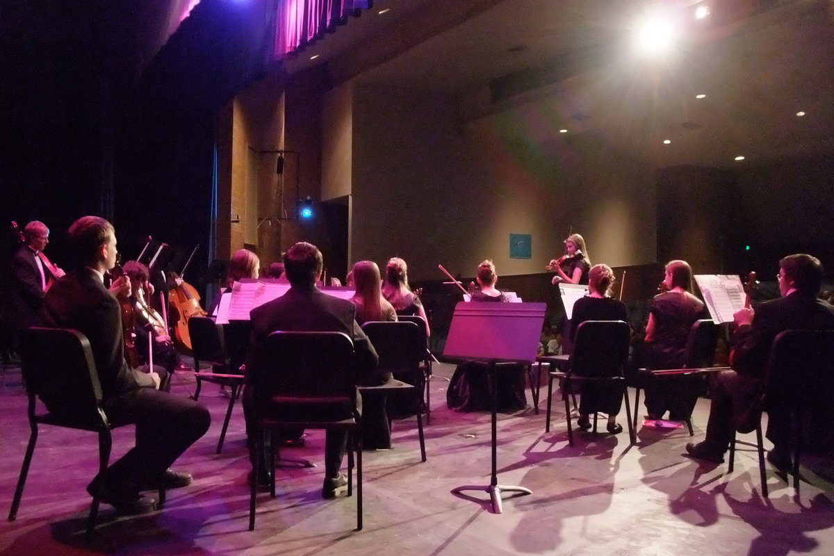 Image: Tuning up — Concert Master Rebecca Young (in front) strikes the tone for the Sky View Orchestra to tune up.