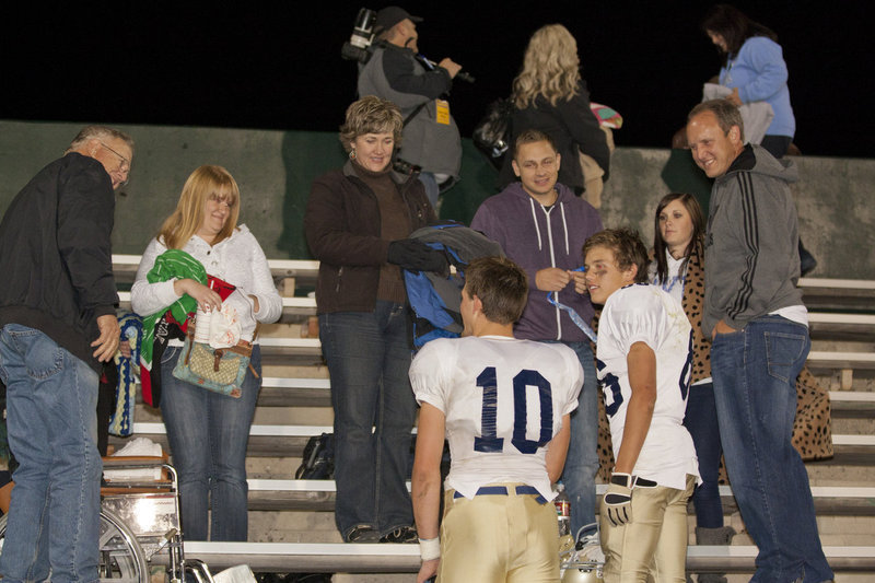 Image: Ethan Dursteller (#10), and Nate Payne (#86) talk to friends and family during after the game