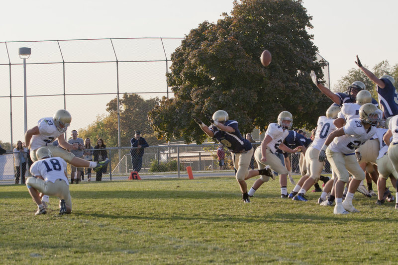 Image: Josh Egbert (#29) adds an extra point while Mitchell Larsen (#18) holds.