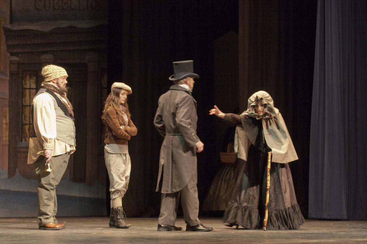Image: Scrooge rebuffs the towns people including a blind woman in the square.