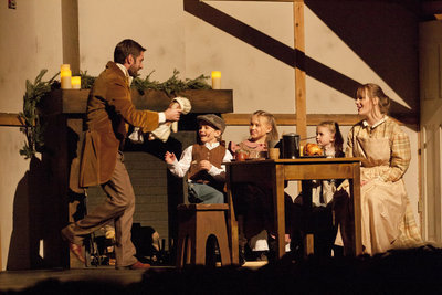 Image: Bob Cratchit hands out a few meager gifts to his family in the Christmas of the present day.