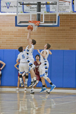 Image: Hayden Downs (35) rebounds, while Dallin Godfrey (5) and John Dumetz (20) are ready to assist.