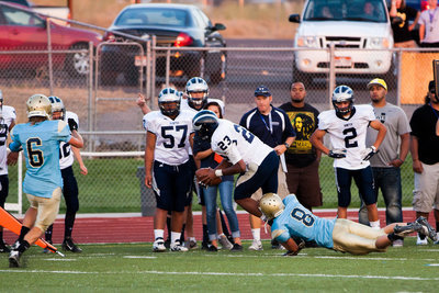 Image: Logan Miller (8) trips up a Wolverine as Brad Weaver (6) closes in to help.